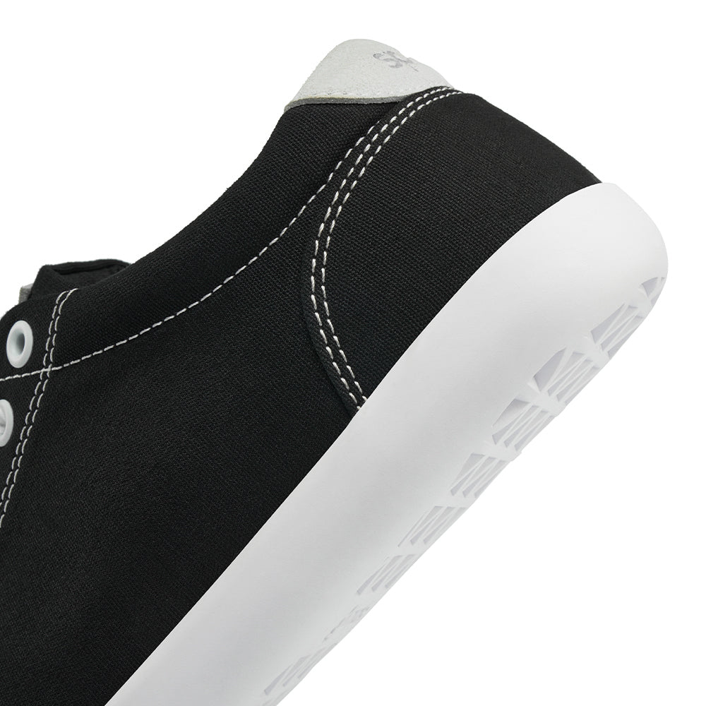 Close up view of the back half of the FREESTYLE 3 Coal, Black sneaker with white eyelets and light grey accents on a white background