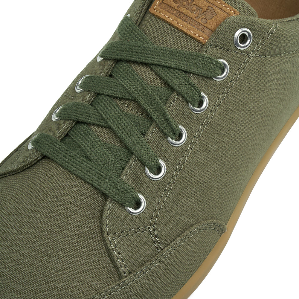 Close up view of the top and laces on the FREESTYLE 3 Pine, Pine green sneaker with matching green laces and brown accents on a white background