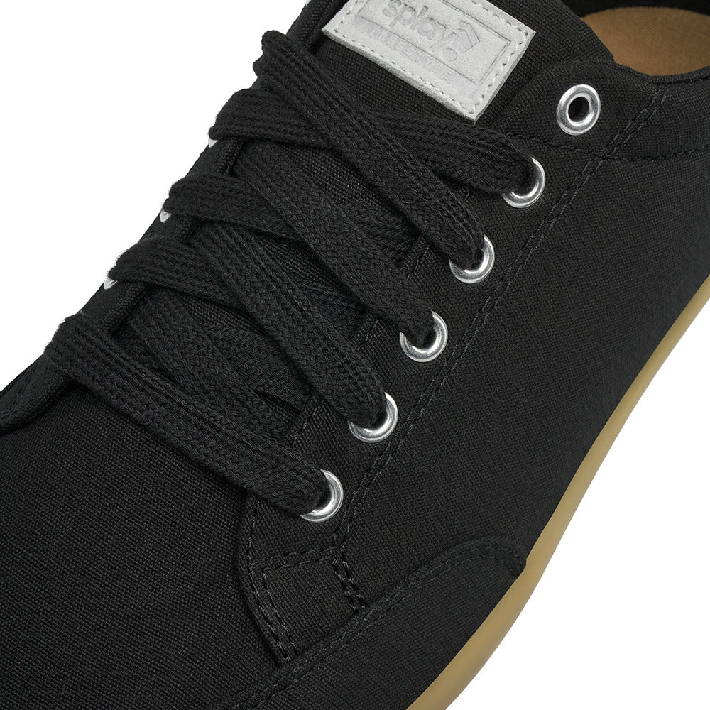 Close up view of the top and laces on the FREESTYLE 3 Shale, black sneaker with black laces and light grey accents on a white background