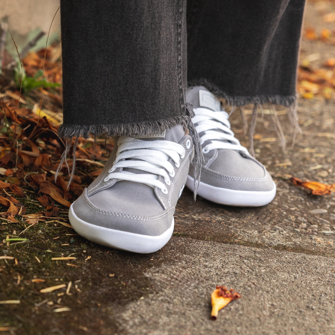Close up picture of the FREESTYLE 3 Stone being worn by a woman standing on a sidewalk in Portland with fall leaves around her feet.