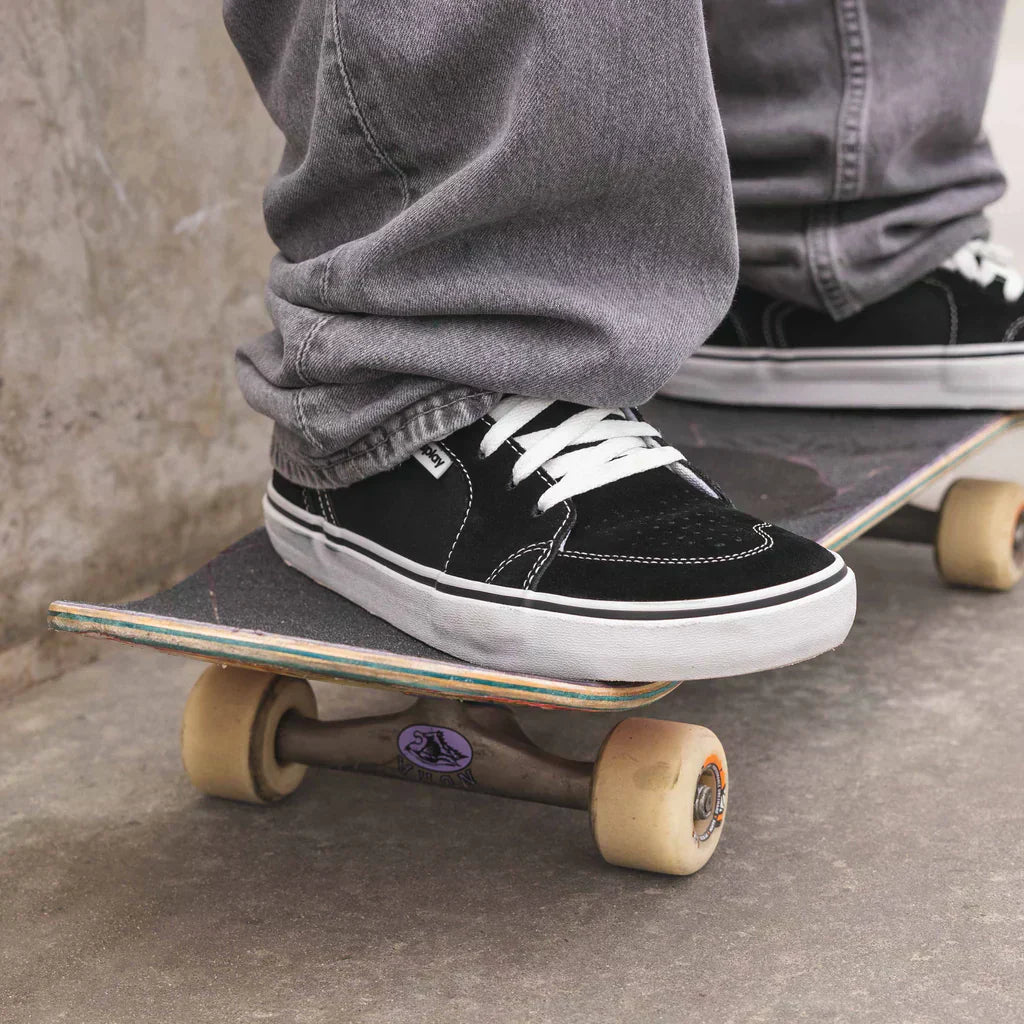 A person wearing REV HTS Los Angeles Splay high-top sneakers while skating.
