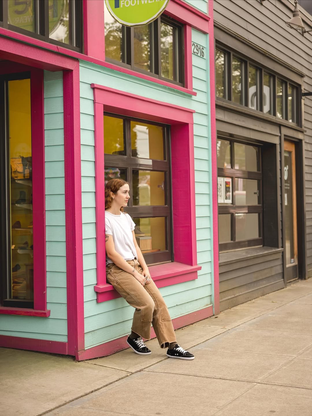 A woman wearing Splay barefoot shoes leaning against a building in a casual urban setting.