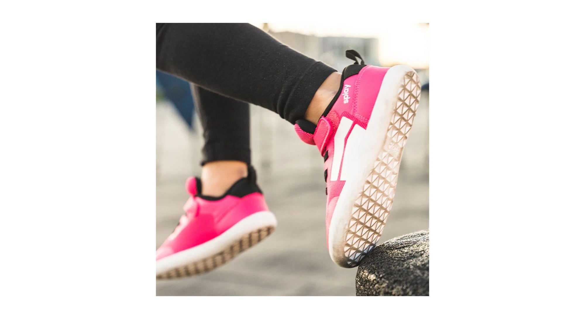 A child wearing the DASH Shock Pink Barefoot Shoes from Splay, showing comfort and flexibility for natural movement.