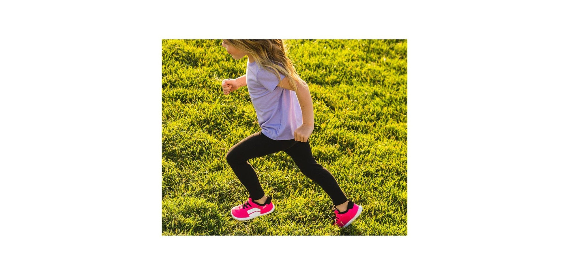 A girl is running on a field wearing a DASH Shock Pink from Splay’s barefoot shoe collection. 