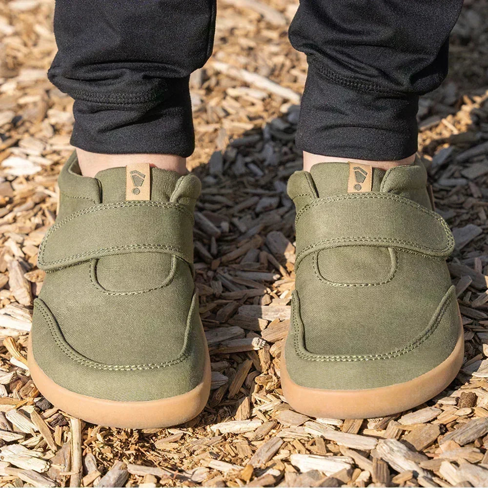 Splay Shoes olive green barefoot shoes with wide toe boxes and hook-and-loop straps outdoors.