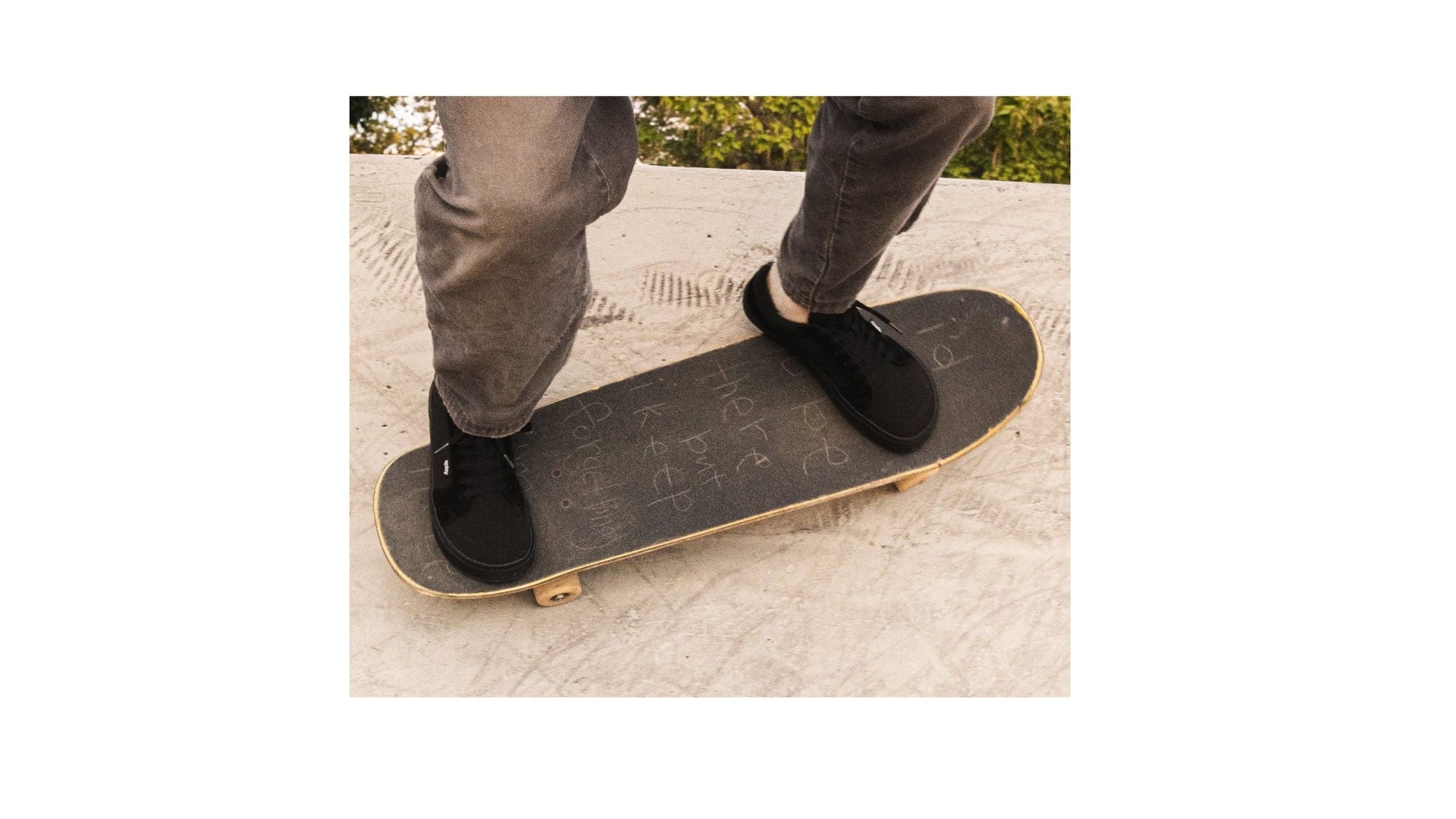 Close-up of a person skateboarding in black Splay minimalist shoes with a wide toe box and zero-drop sole