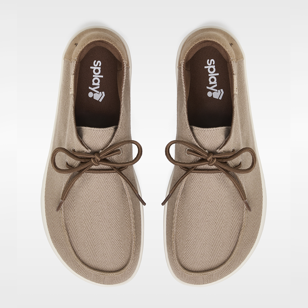 Pair of tan shoes with brown laces on a white background