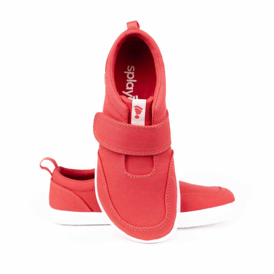 Kids' bright red zero drop shoe with velcro strap and white sole supporting natural movement.