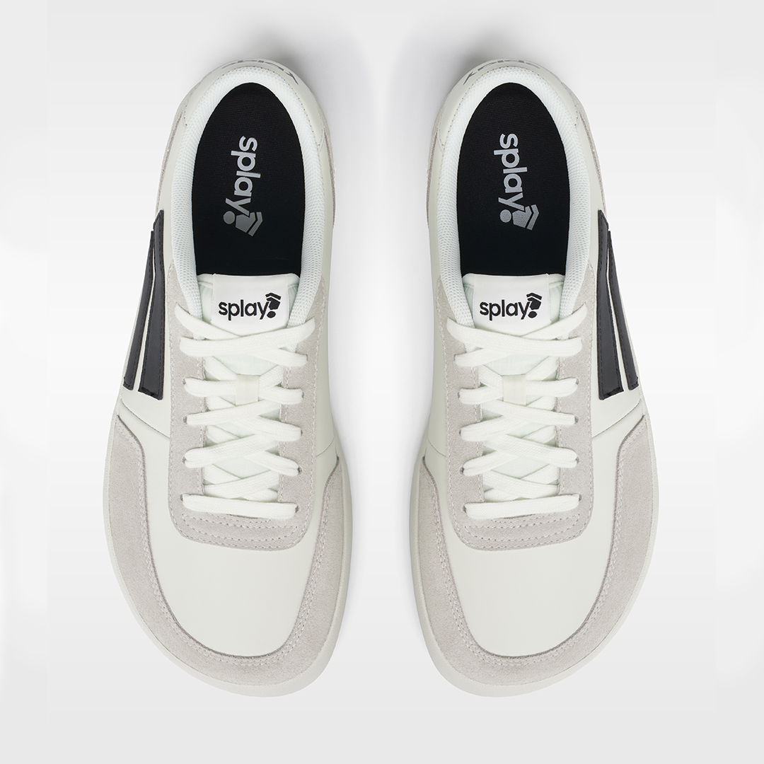 White sneakers with black accents and 'splay' logo on a white background