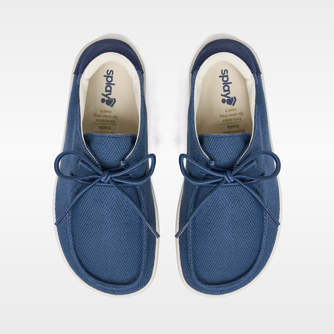 Pair of blue sneakers with white soles on a light gray background