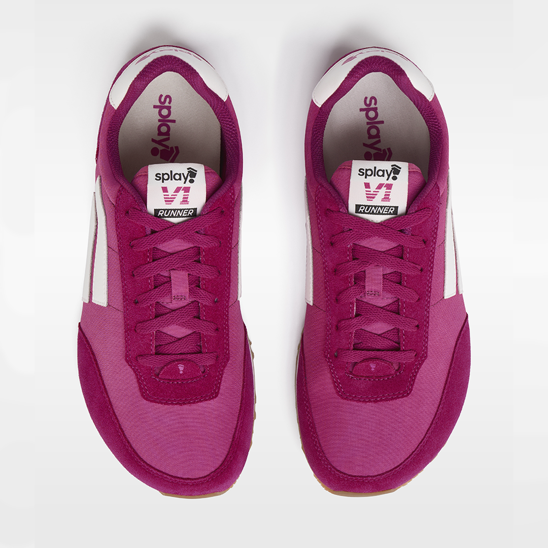 Pair of pink sneakers with white soles on a light gray background