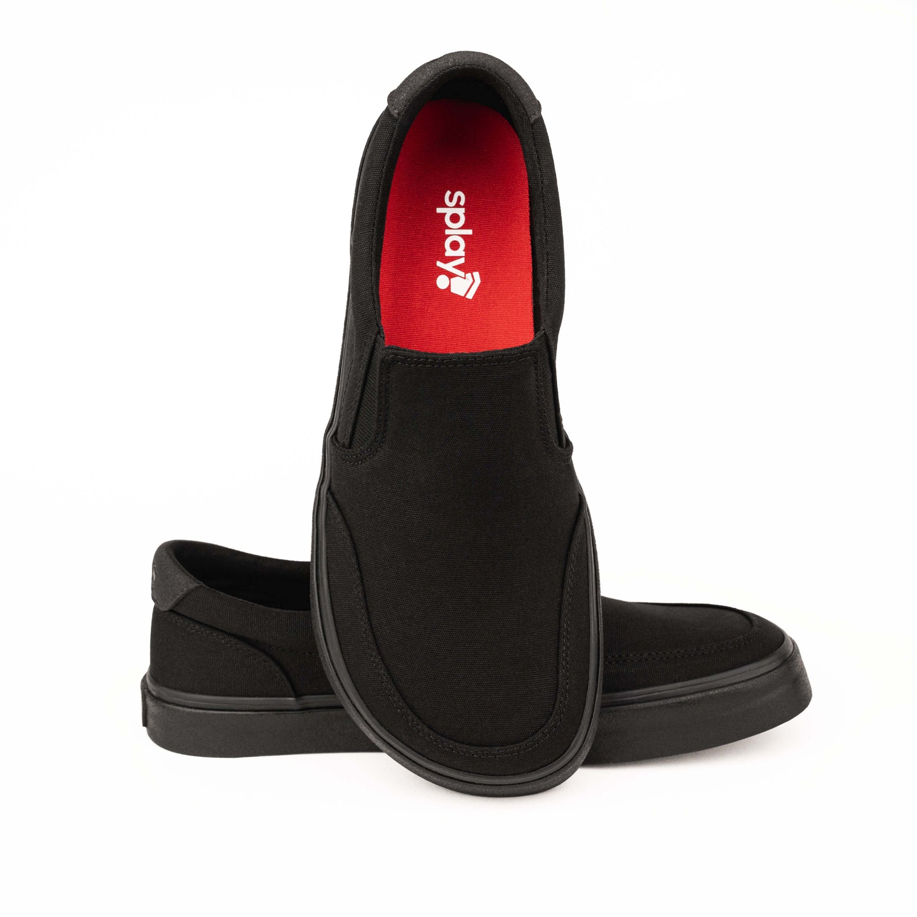 Close-up of black Splay STREESTYLE SLIP-ON shoes, featuring a minimalist design with a black sole and red interior with the Splay logo.