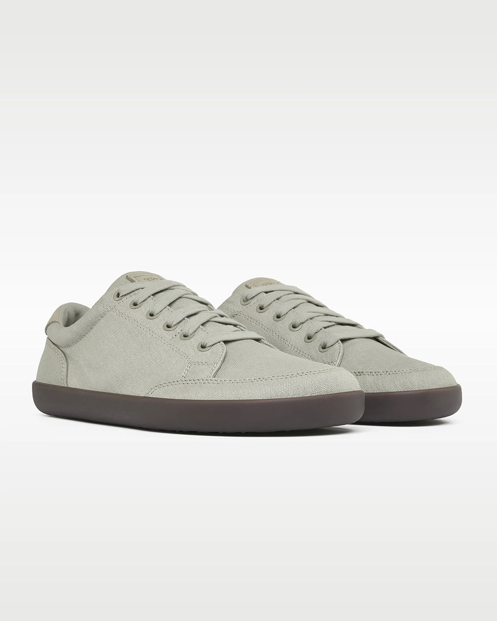 Front three-quarter view of a pair of Splay FREESTYLE Ash '26 light gray canvas barefoot sneakers with dark gray soles.