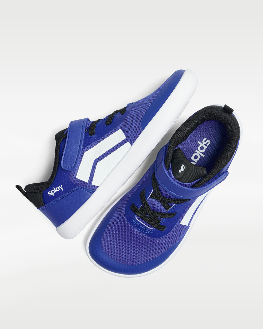 Splay Dash Kids True Blue barefoot shoes — kids' low-top sneaker with a strap and laces, pair shot from above, one shoe tipped up to show the insole