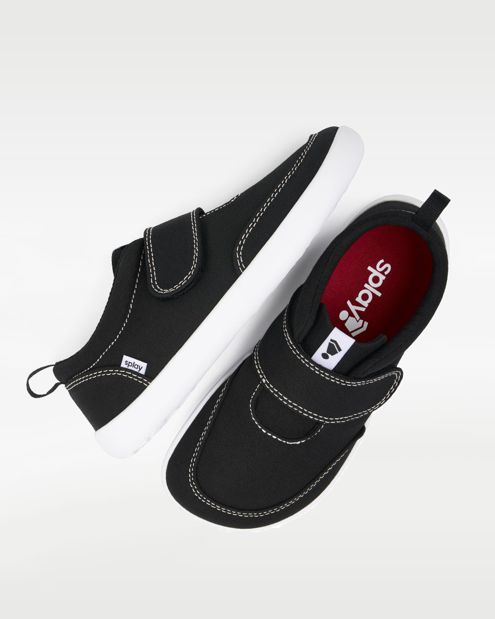 Splay Explore Kids Coal barefoot shoes — kids' low-top shoe with a hook-and-loop strap, pair shot from above, one shoe tipped up to show the insole