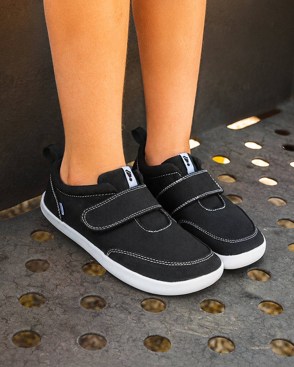 Splay Explore Kids Coal barefoot shoes — kids' low-top shoe with a hook-and-loop strap, lifestyle photo, the shoes shown in use outdoors