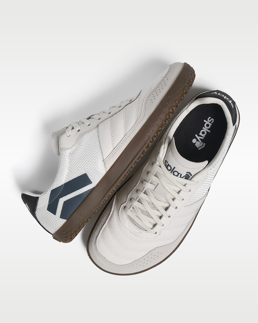 DOMINARI Lux barefoot shoes — low-top indoor soccer shoe with a gum sole, pair shot from above, one shoe tipped up to show the insole