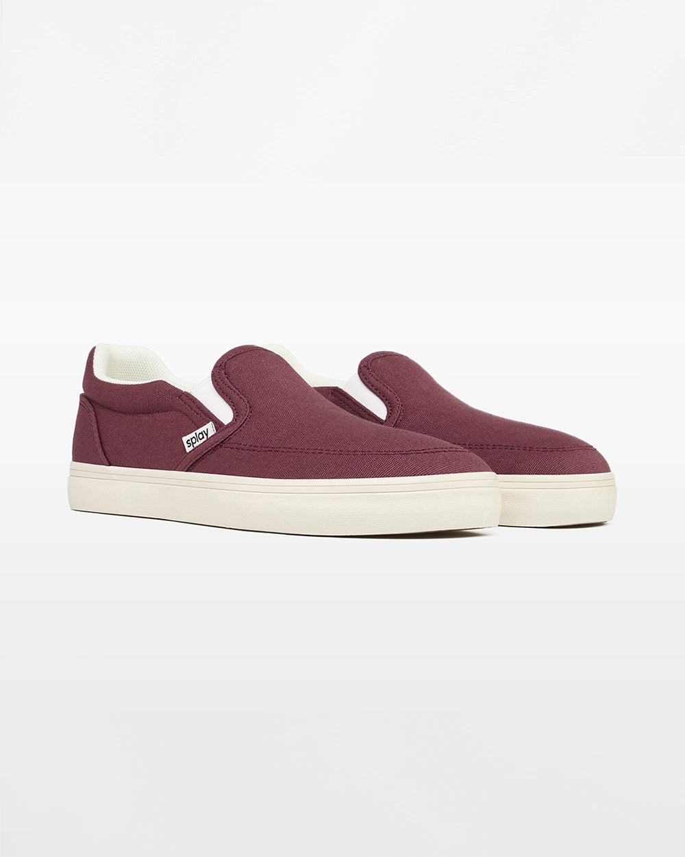 Angled front view of a pair of burgundy Splay Kids REV SO Madrid canvas barefoot slip-on shoes with white soles.