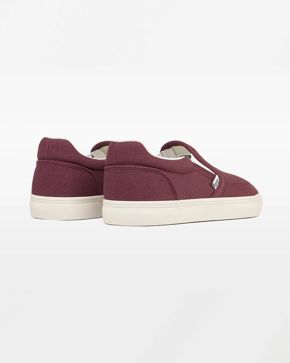 Rear angled view of a pair of burgundy Splay Kids REV SO Madrid canvas barefoot slip-on shoes with white soles.