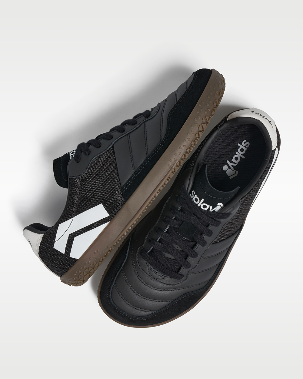 DOMINARI Nox barefoot shoes — low-top indoor soccer shoe with a gum sole, pair shot from above, one shoe tipped up to show the insole