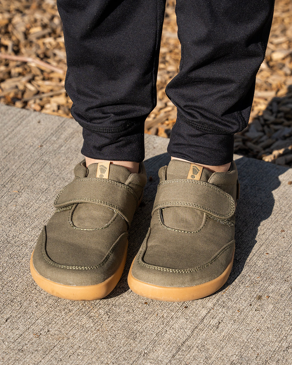 Splay Explore Kids Pine barefoot shoes — kids' low-top shoe with a hook-and-loop strap, lifestyle photo, the shoes shown in use outdoors