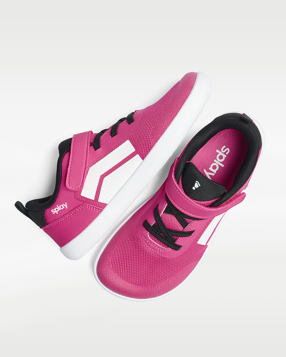 Splay Dash Kids Shock Pink barefoot shoes — kids' low-top sneaker with a strap and laces, pair shot from above, one shoe tipped up to show the insole