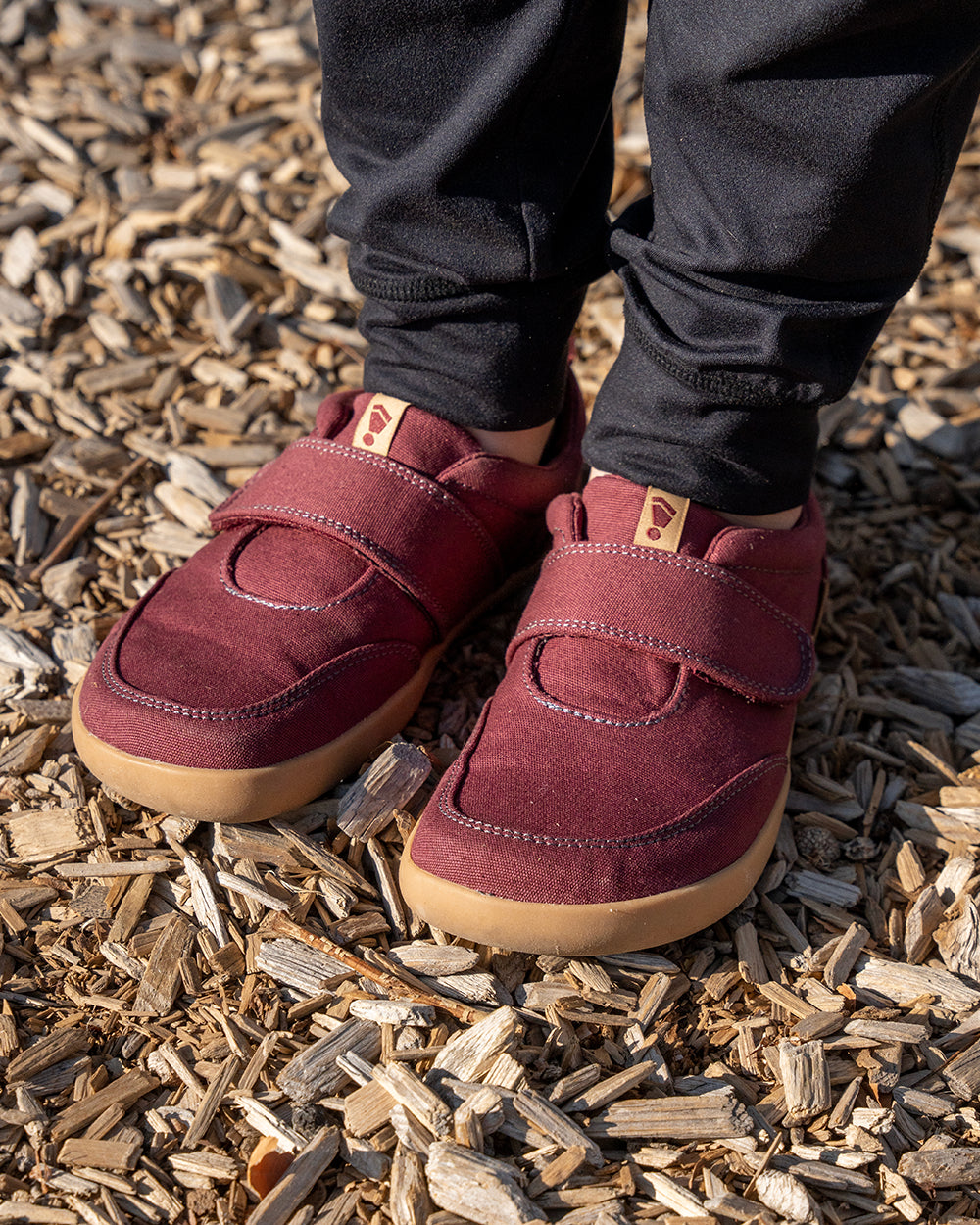 Splay Explore Kids Plum barefoot shoes — kids' low-top shoe with a hook-and-loop strap, lifestyle photo, the shoes shown in use outdoors