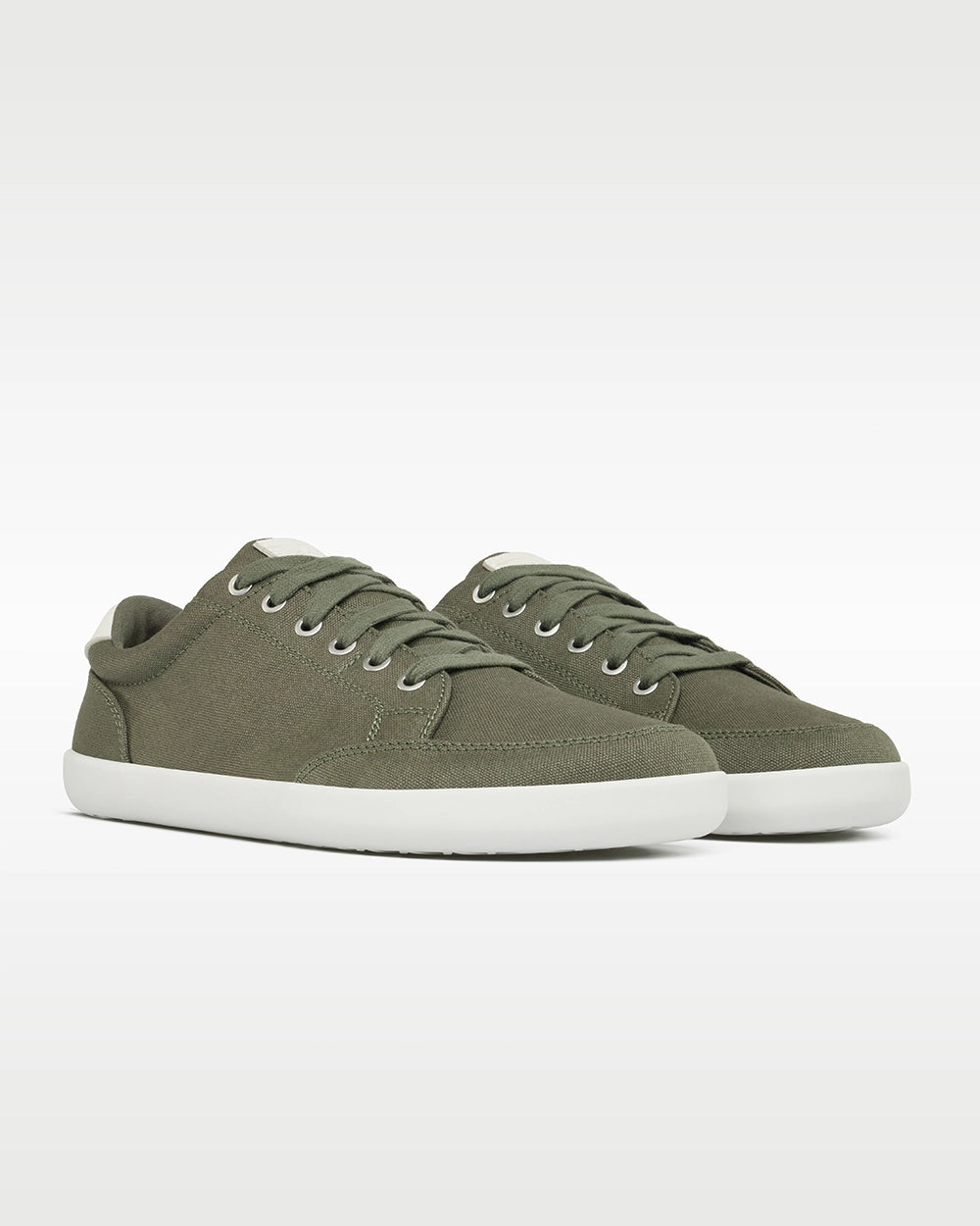 Front three-quarter view of a pair of Splay FREESTYLE Sage '26 green canvas barefoot sneakers with white soles.
