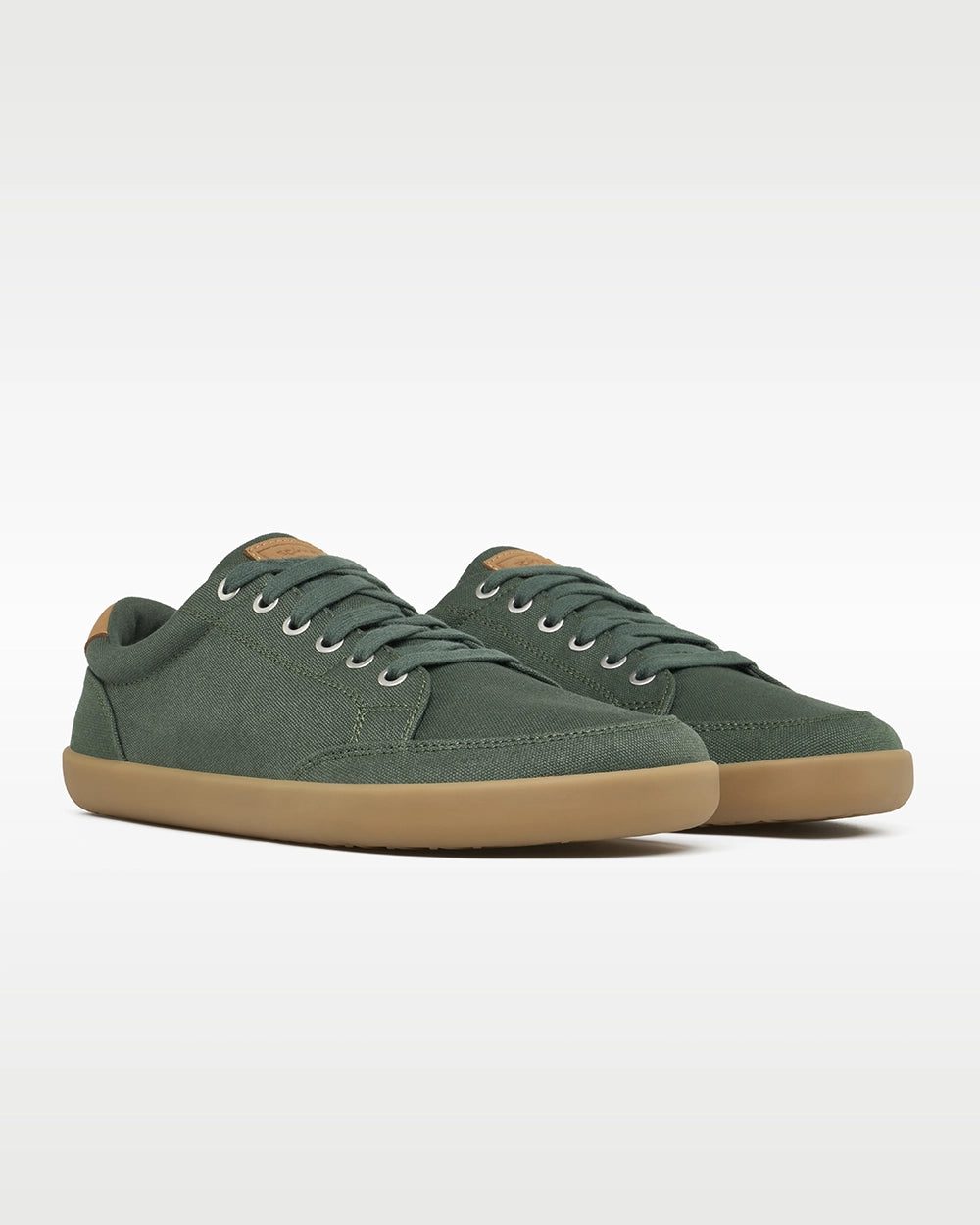 Front three-quarter view of a pair of Splay FREESTYLE Spruce '26 green canvas barefoot sneakers with gum soles.
