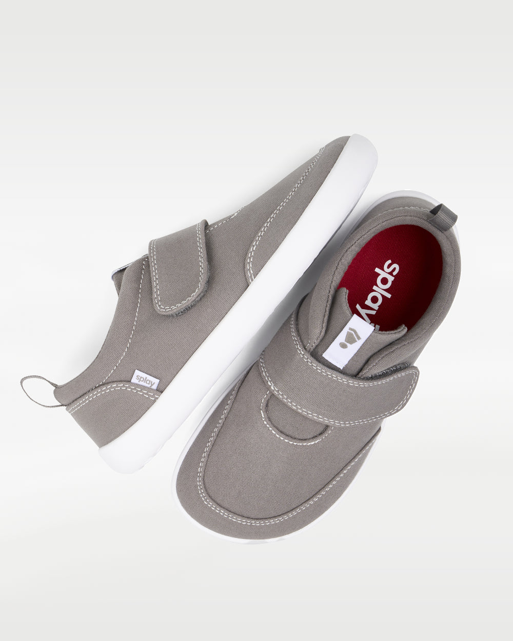 Splay Explore Kids Stone barefoot shoes — kids' low-top shoe with a hook-and-loop strap, pair shot from above, one shoe tipped up to show the insole
