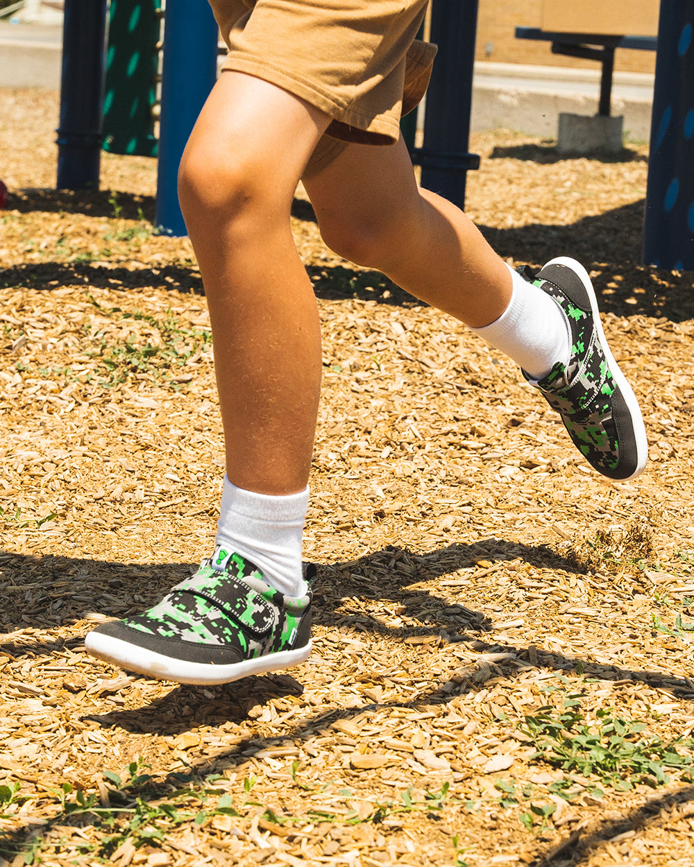 Splay Explore Wild Kids Digicam Green barefoot shoes — kids' low-top shoe with a hook-and-loop strap, lifestyle photo, the shoes shown in use outdoors