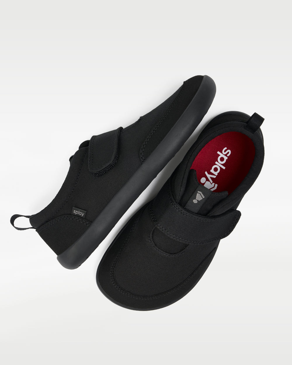 Splay Explore Wild Kids Jet barefoot shoes — kids' low-top shoe with a hook-and-loop strap, pair shot from above, one shoe tipped up to show the insole