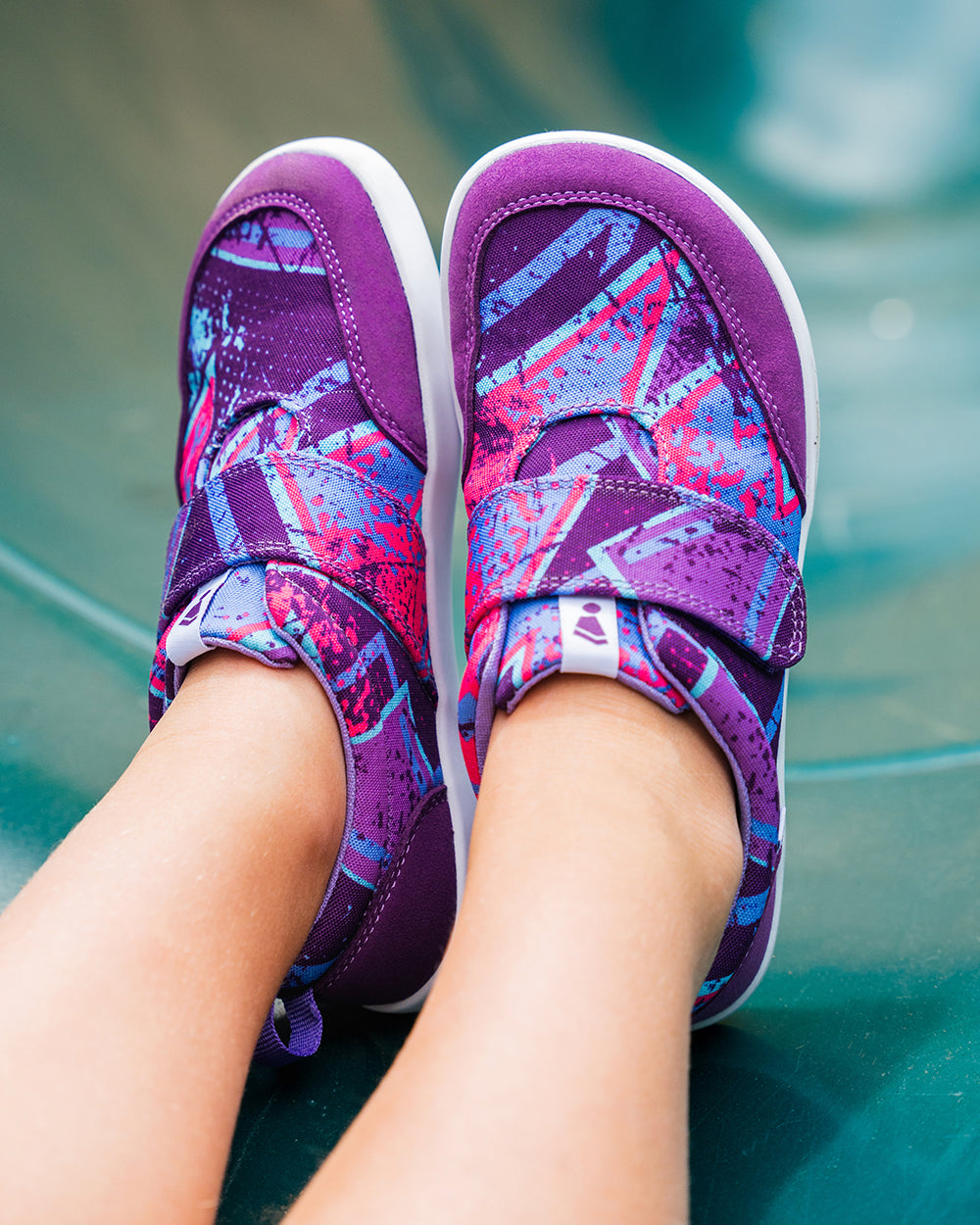 Splay Explore Wild Kids Purple Pop barefoot shoes — kids' low-top shoe with a hook-and-loop strap, lifestyle photo, the shoes shown in use outdoors