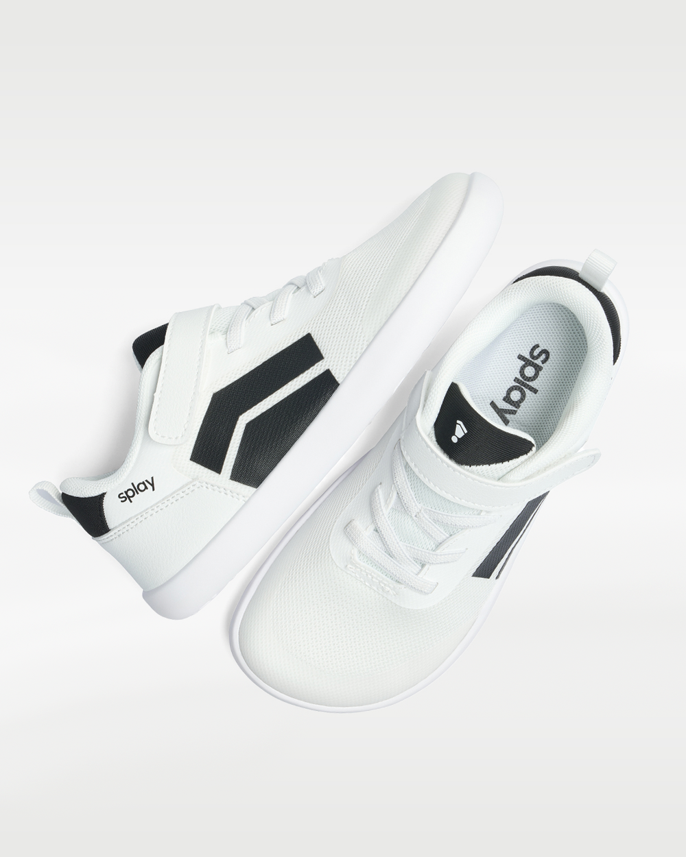 Splay Dash Kids Spark White barefoot shoes — kids' low-top sneaker with a strap and laces, pair shot from above, one shoe tipped up to show the insole